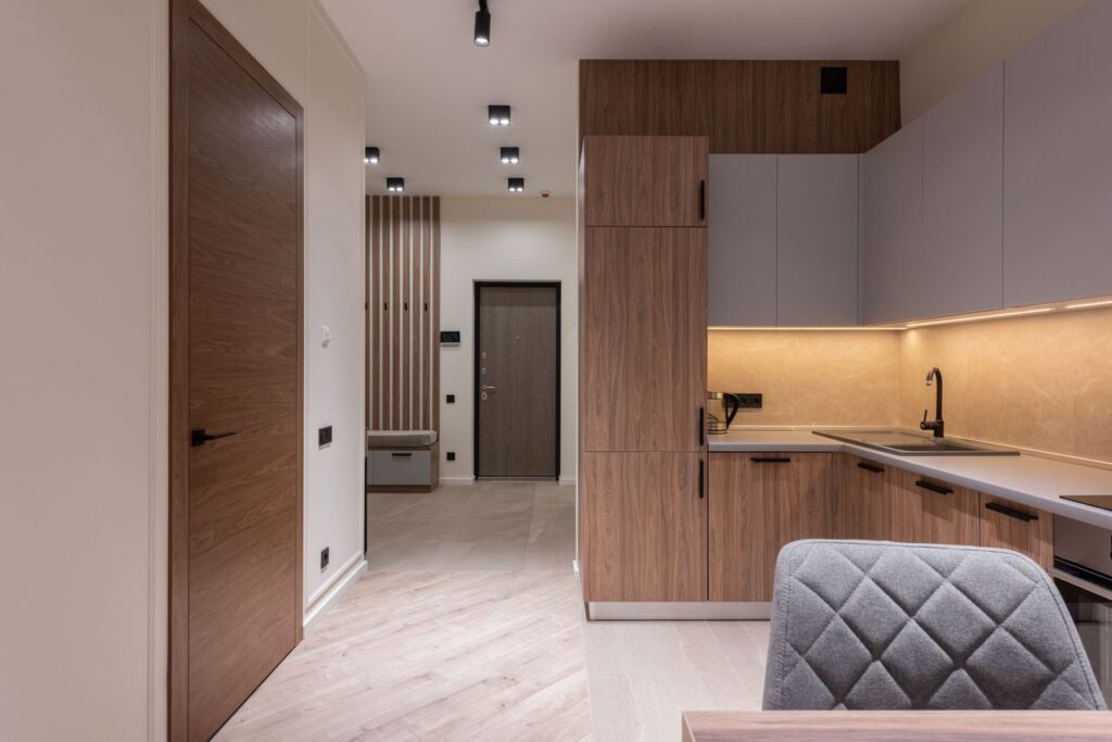 Interior design of spacious kitchen with furniture and appliances and entrance hall in modern apartment